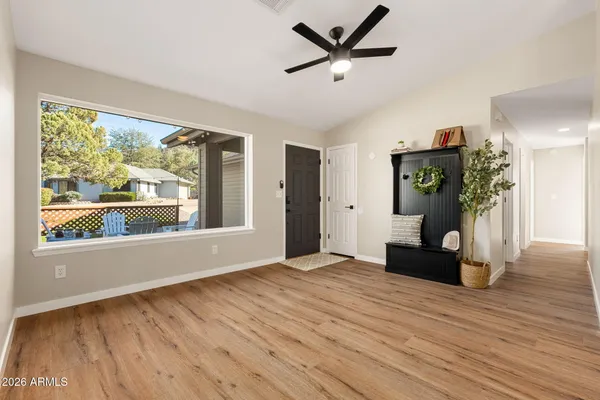 a view of an empty room with wooden floor and a window