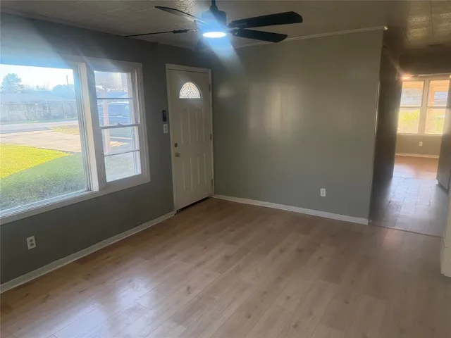 an empty room with wooden floor and mirror