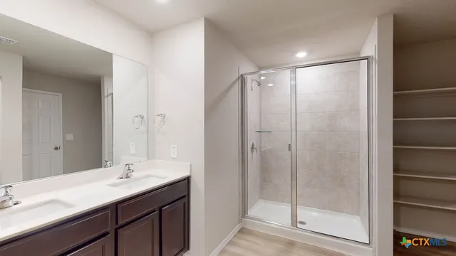 a bathroom with a shower sink vanity and mirror