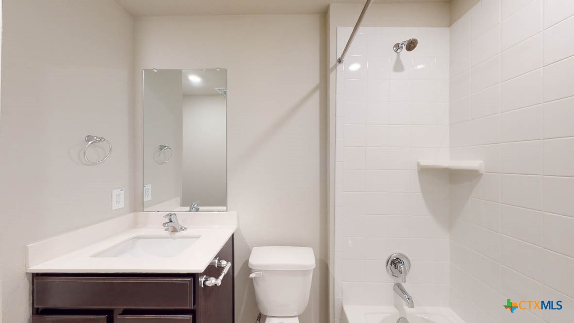 1310 Merritt Road Temple, TX 76504 - Photo 26 of 28 a bathroom with a toilet a sink a mirror and vanity