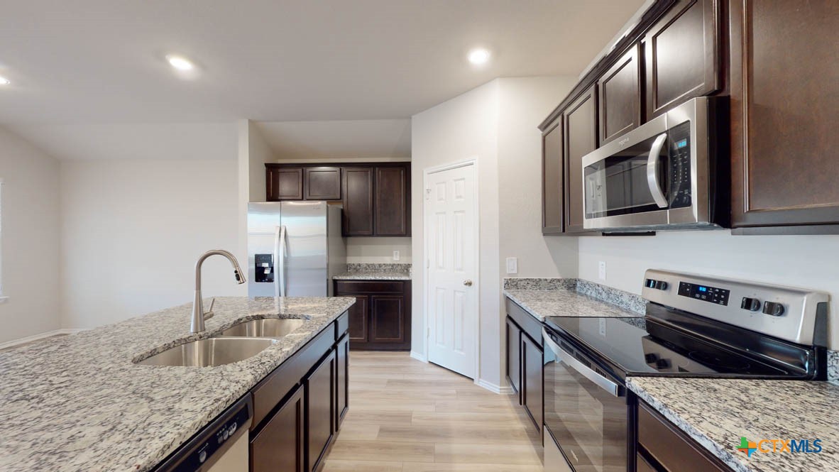 1310 Merritt Road Temple, TX 76504 - Photo 7 of 28 a kitchen with stainless steel appliances granite countertop a sink stove and refrigerator