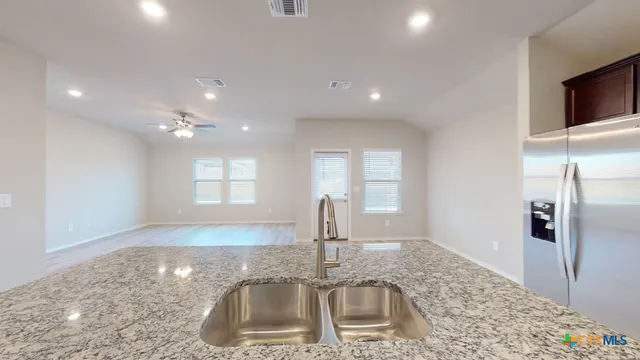 a kitchen with kitchen island a sink stainless steel appliances and a counter top