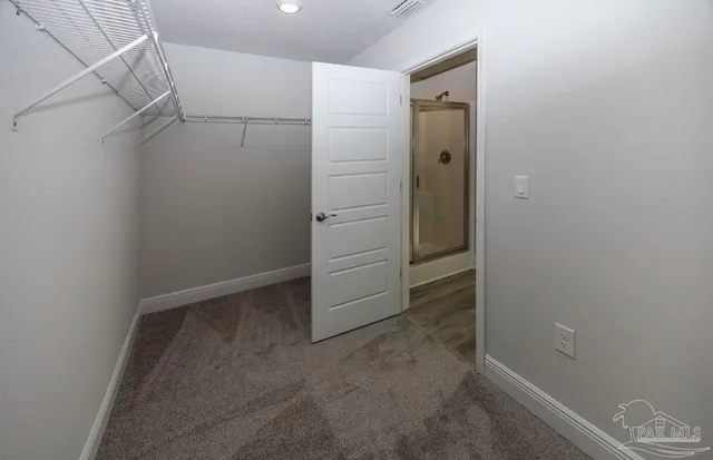 an empty room with a wooden door and mirror