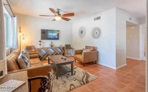 a living room with furniture a flat screen tv and a window