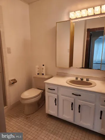 a bathroom with a granite countertop toilet sink and mirror