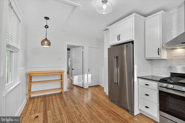 a kitchen with stainless steel appliances a stove a refrigerator and cabinets