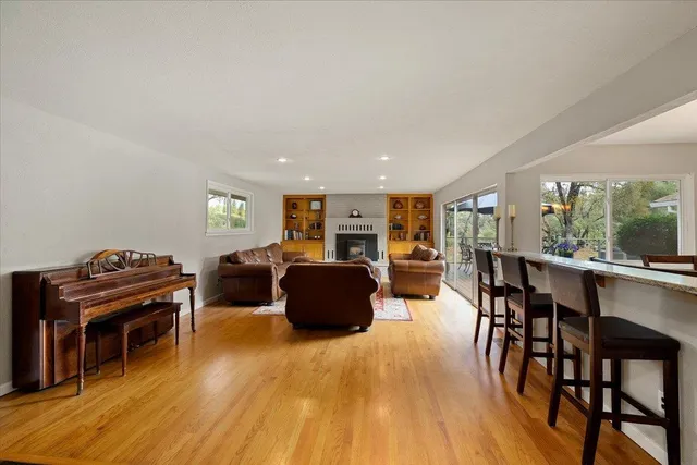 a dining room with wooden floor a chandelier a wooden table and chairs