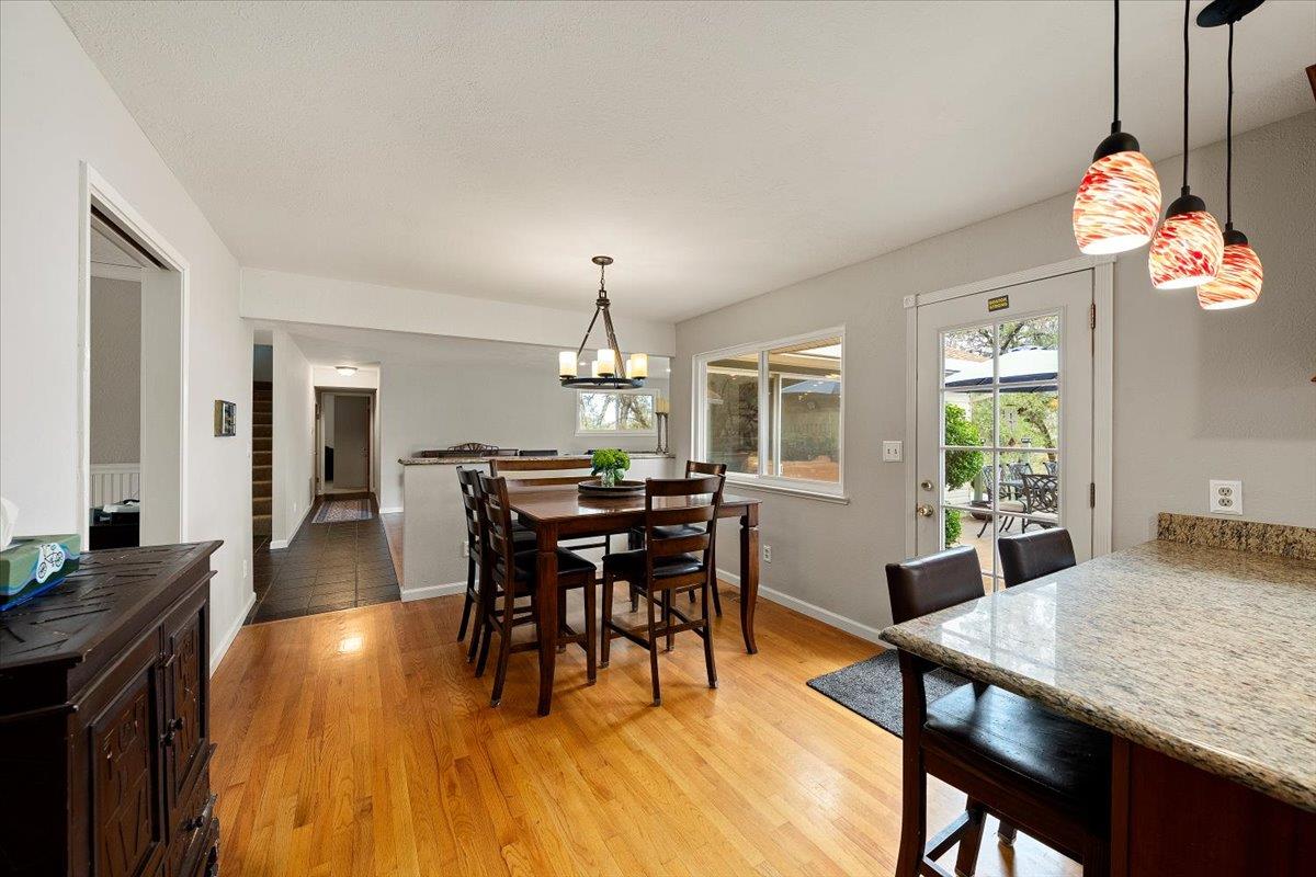 2540 Muir Court Cool, CA 95614 - Photo 28 of 97 a dining room with wooden floor a chandelier a wooden table and chairs