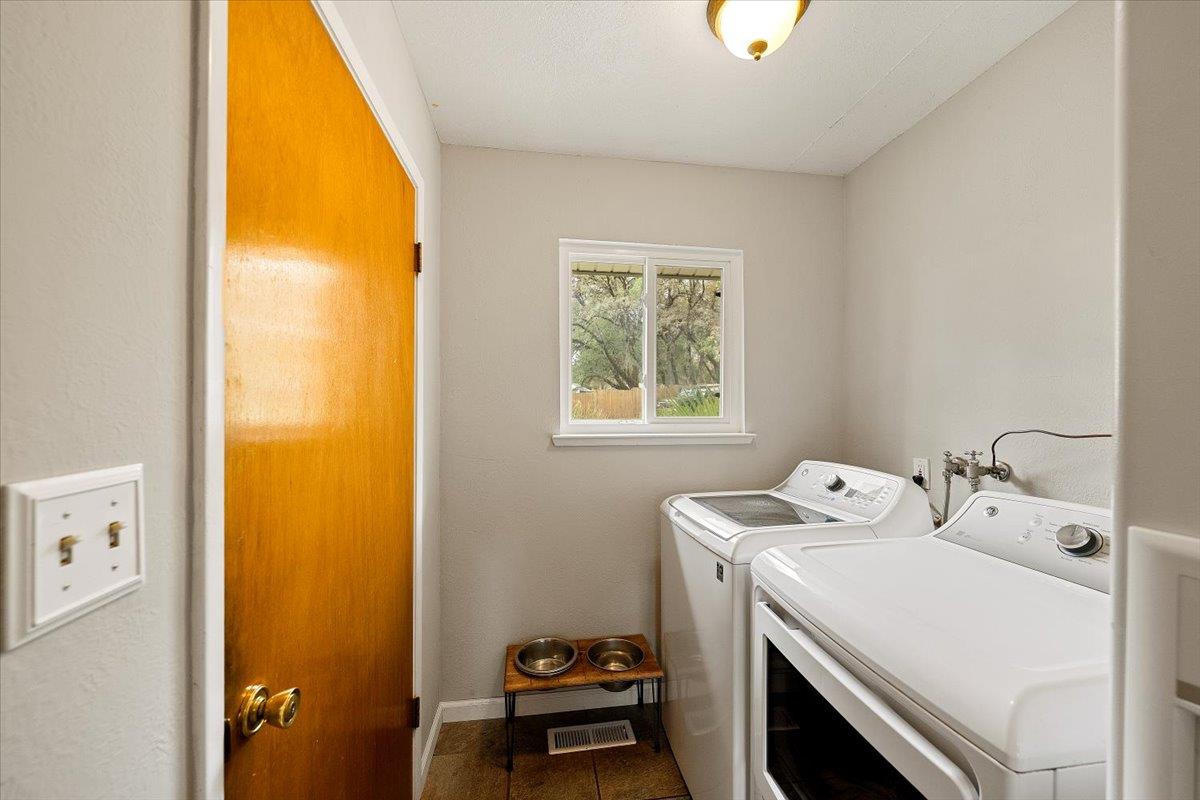 2540 Muir Court Cool, CA 95614 - Photo 30 of 97 washroom with washer and dryer and dark tile patterned flooring