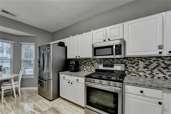 a bathroom with a granite countertop sink and a white cabinets