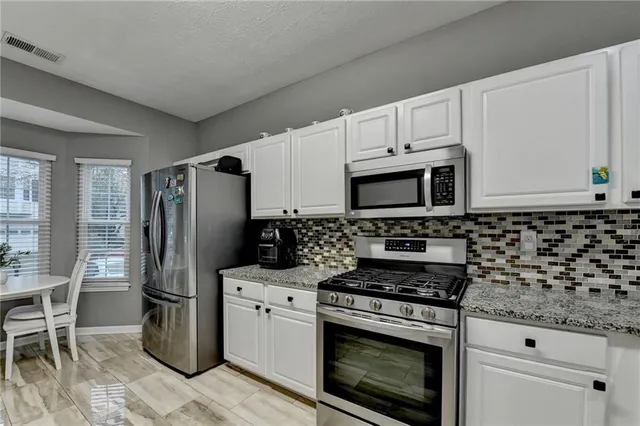 a bathroom with a granite countertop sink and a white cabinets