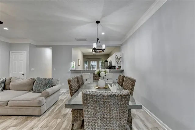 a living room with furniture a chandelier and a flat screen tv