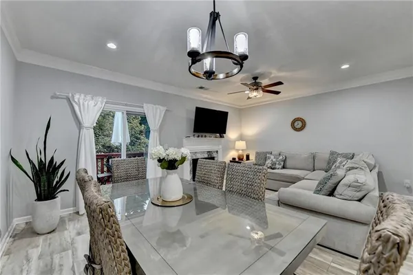 a kitchen with a table chairs and a living room view