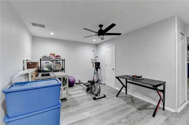a bedroom with a bed couch and a ceiling fan