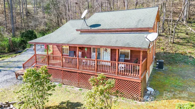 a view of a house with a small yard and deck