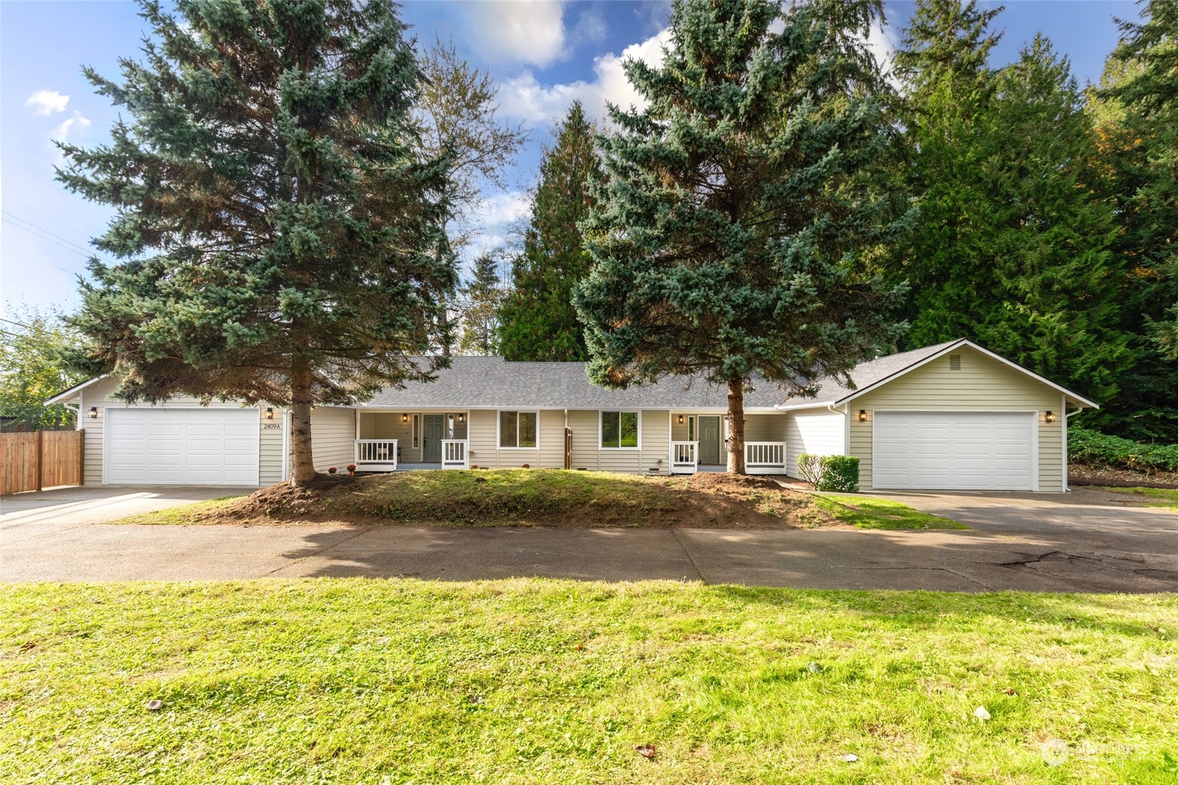 a view of a yard in front of a house with a large tree