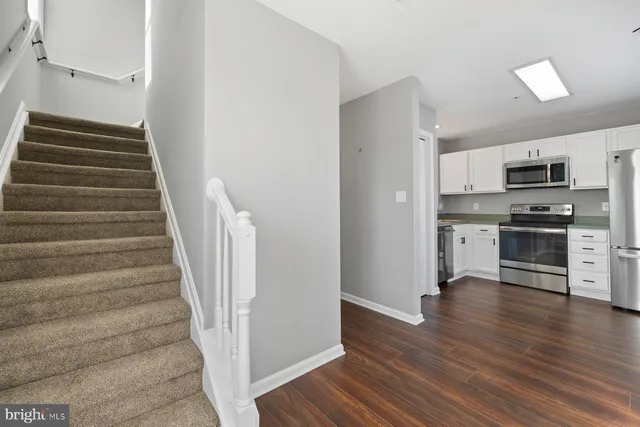 a view of a kitchen with wooden floor and electronic appliances