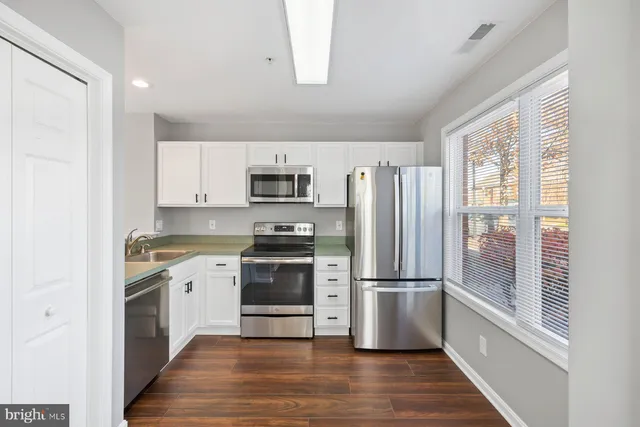 a kitchen with stainless steel appliances a refrigerator sink and microwave
