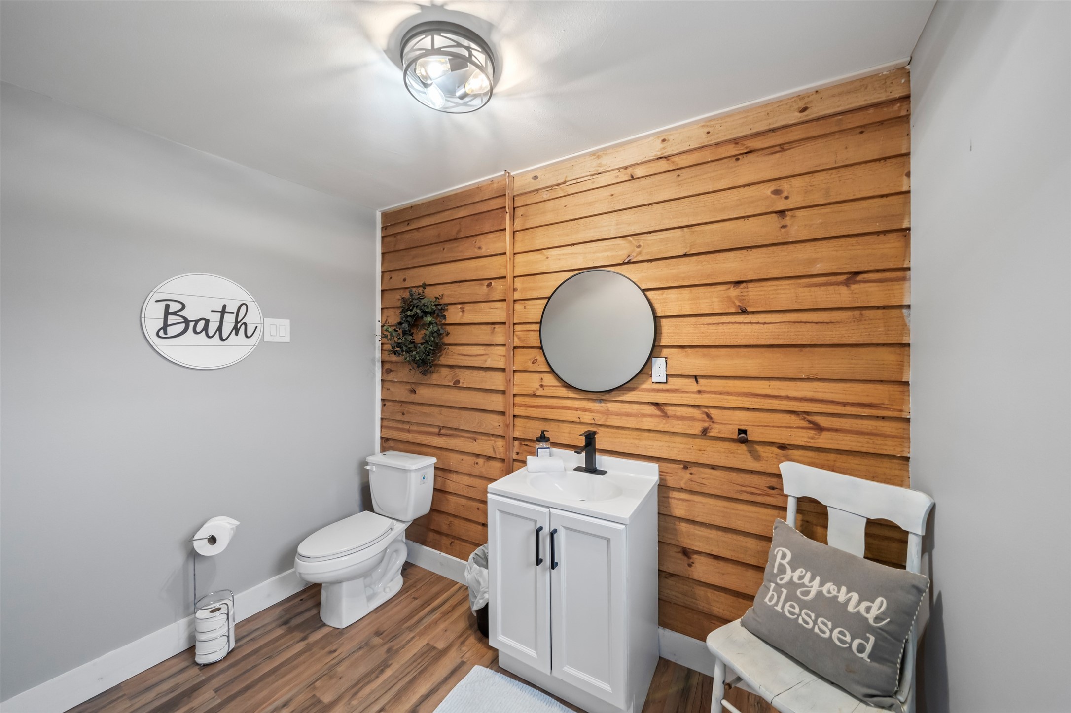 10630 Padon Road Needville, TX 77461 - Photo 19 of 50 Guest bathroom includes updated fixtures, a modern vanity, and a wood accent wall that adds warmth and character. Clean lines and durable finishes make the space both functional and inviting.