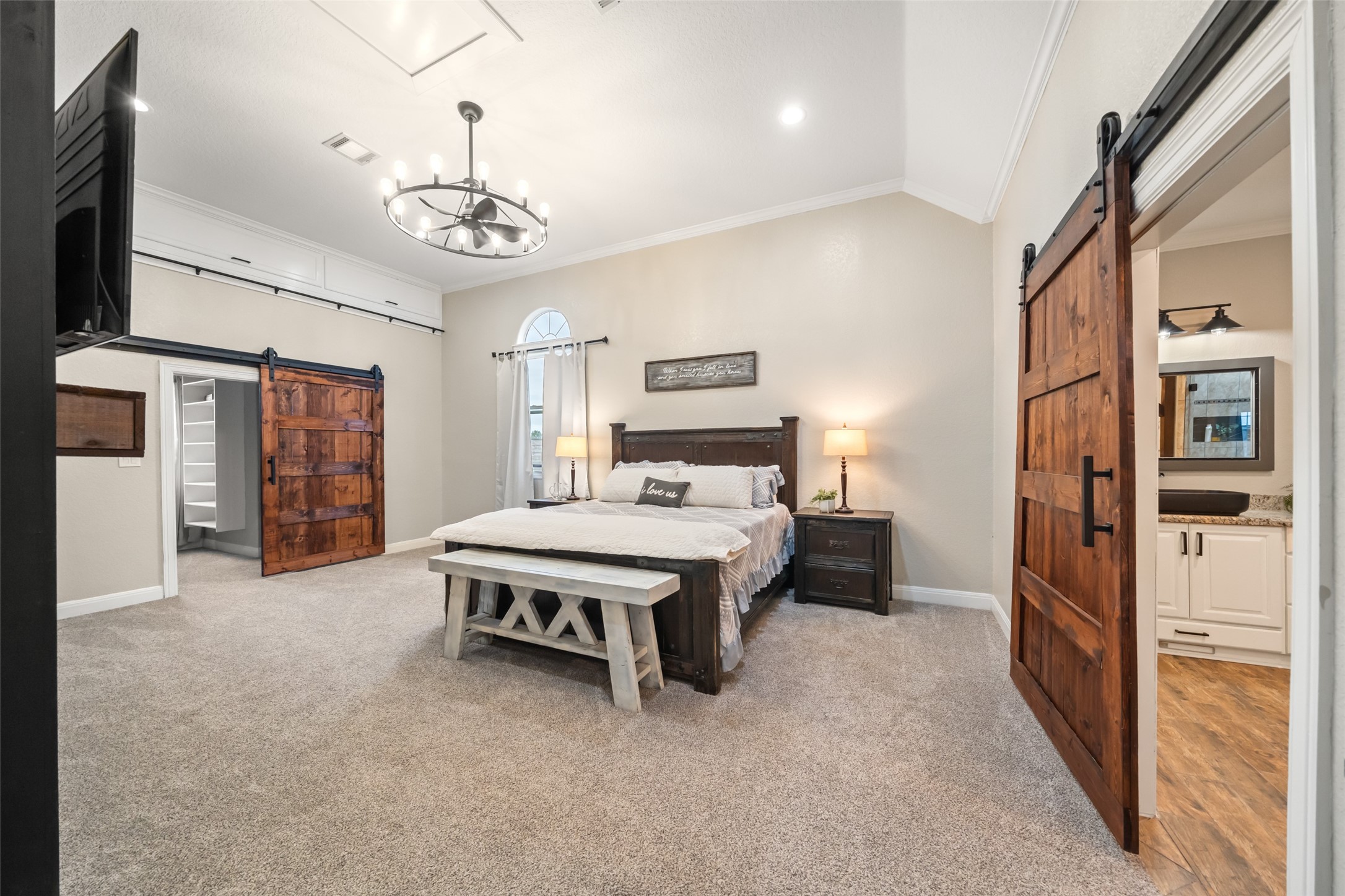 10630 Padon Road Needville, TX 77461 - Photo 20 of 50 Primary bedroom offers generous proportions with plush carpet, custom barn doors, and ample wall space for furniture placement. Neutral tones provide a calm, cohesive feel.