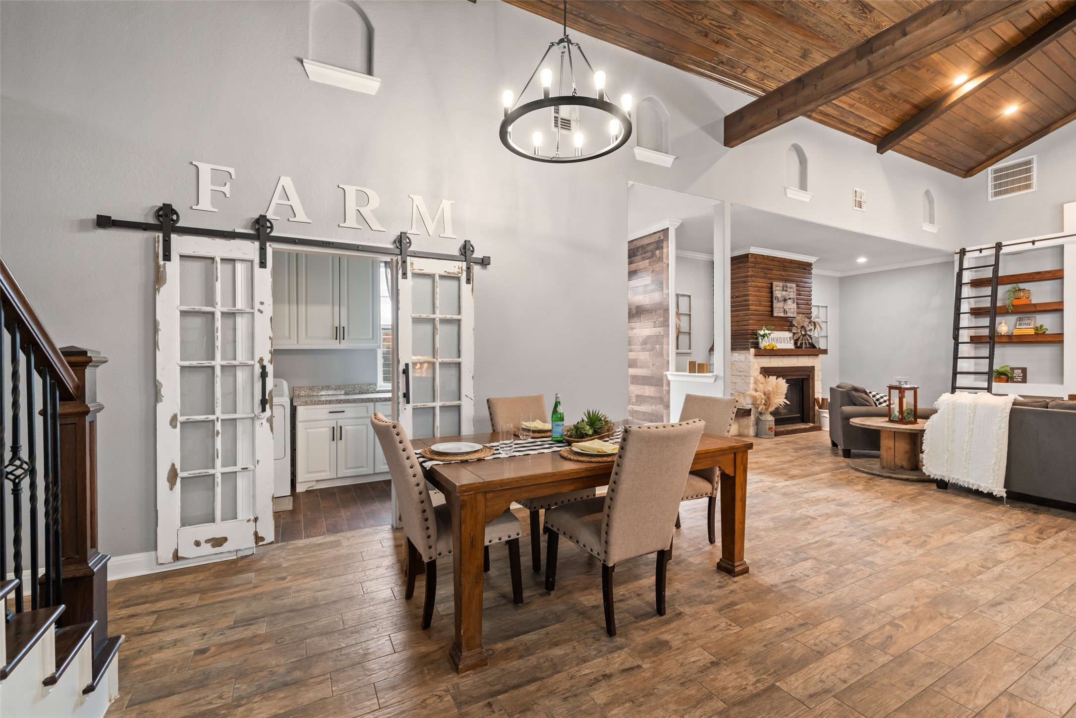 10630 Padon Road Needville, TX 77461 - Photo 21 of 50 Dining area sits beneath soaring ceilings and modern chandeliers, with easy flow to both the kitchen and living room. Sliding barn doors add farmhouse-style character.