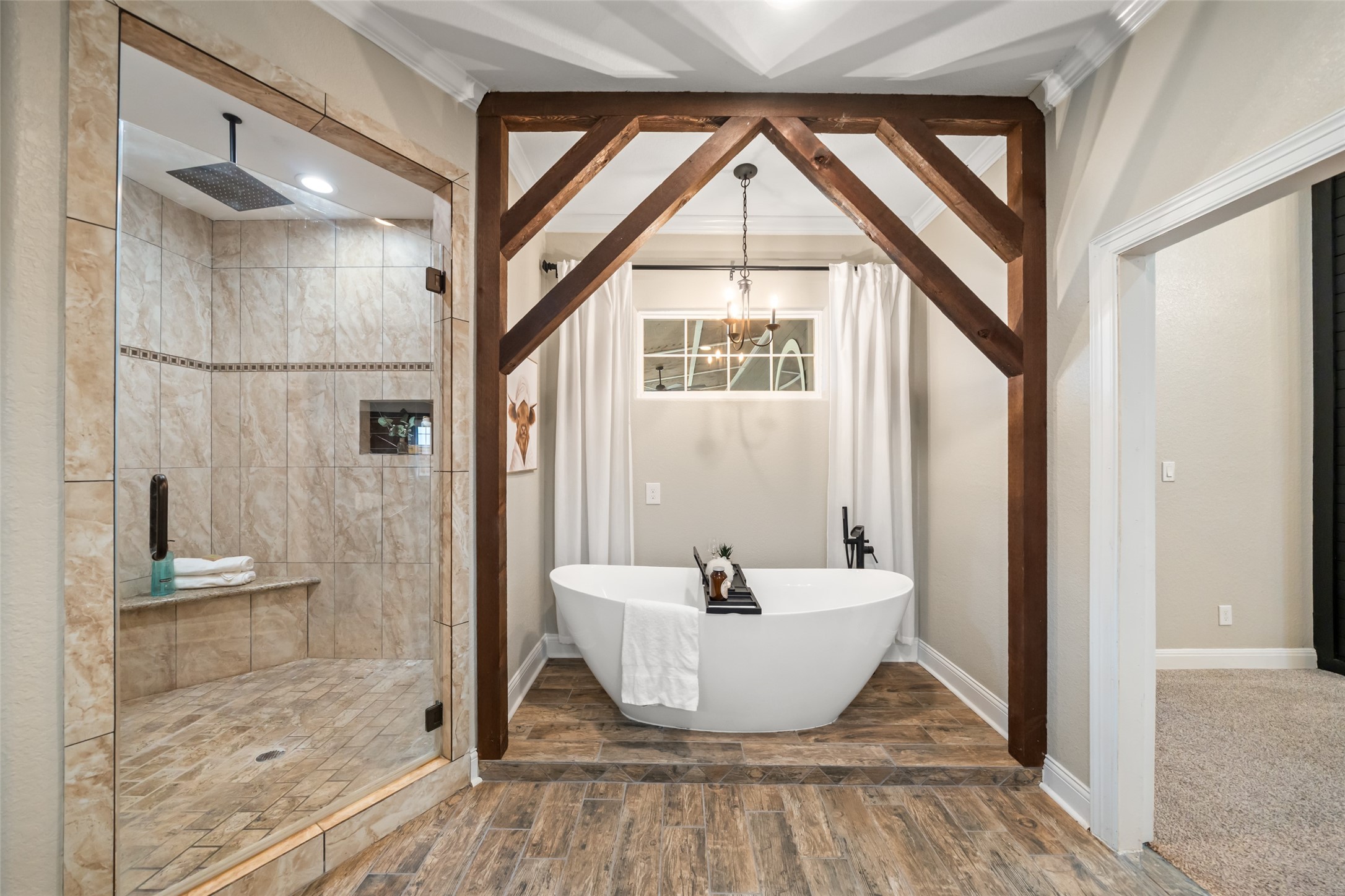 10630 Padon Road Needville, TX 77461 - Photo 25 of 50 Spa-style bathroom includes a walk-in tiled shower and a freestanding soaking tub framed by custom wood detailing. Durable finishes and thoughtful design create a polished, functional space.