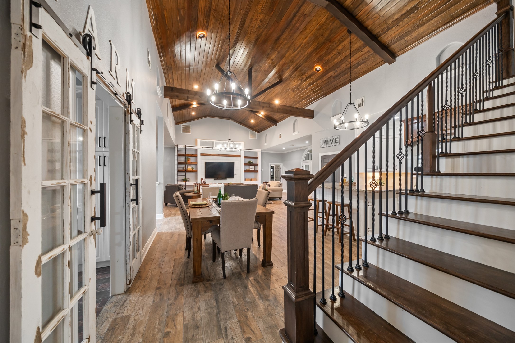 10630 Padon Road Needville, TX 77461 - Photo 28 of 50 Staircase and dining area view showcases iron balusters, wood stair treads, and open sightlines to the living room. The design emphasizes flow and scale.