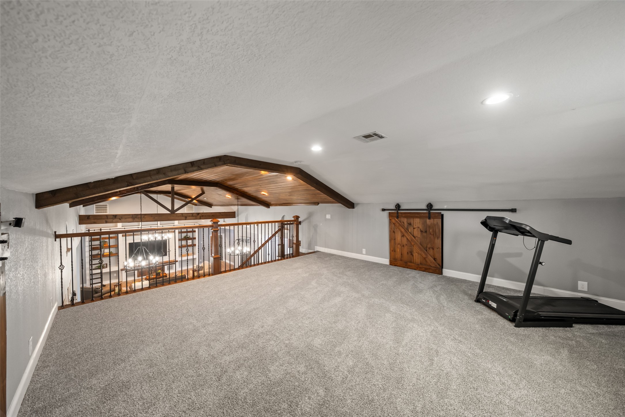 10630 Padon Road Needville, TX 77461 - Photo 33 of 50 Alternate loft view overlooks the main living area, highlighting exposed beams and railing detail. The space provides privacy while maintaining connection to the home below.