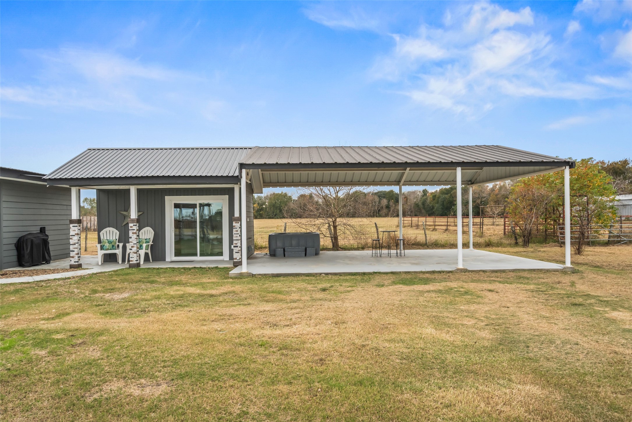 10630 Padon Road Needville, TX 77461 - Photo 9 of 50 Rear patio provides a covered hot tub area with direct access to the home. Concrete flooring and open sightlines make the space easy to enjoy and maintain.