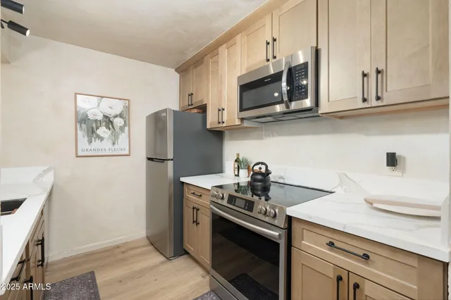 a kitchen with stainless steel appliances granite countertop a sink stove and microwave