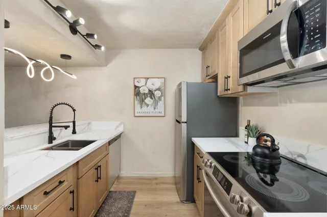 a kitchen with stainless steel appliances granite countertop a sink stove and refrigerator
