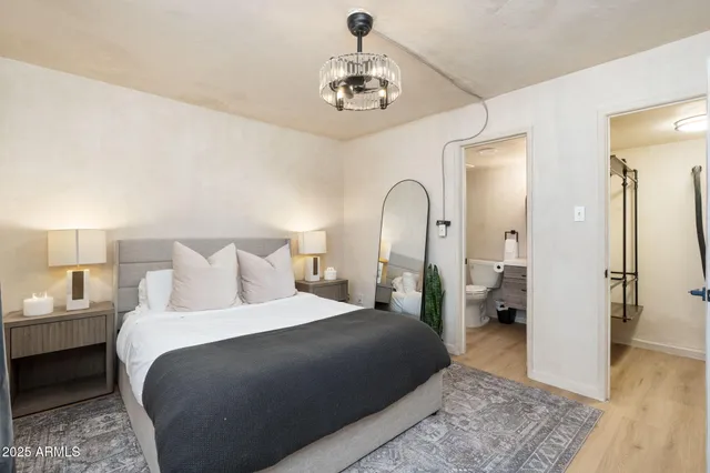 a bedroom with a bed and a chandelier