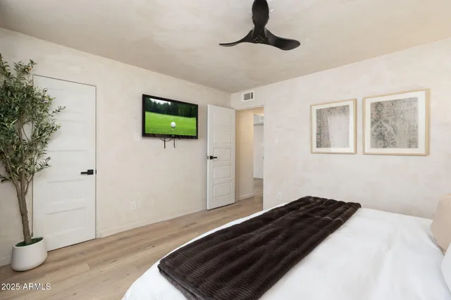 a bedroom with a bed and a painting on the wall