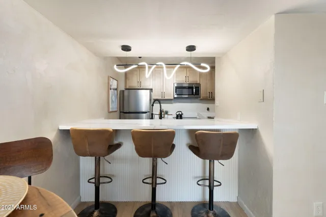 a kitchen with a dining table chairs and a microwave