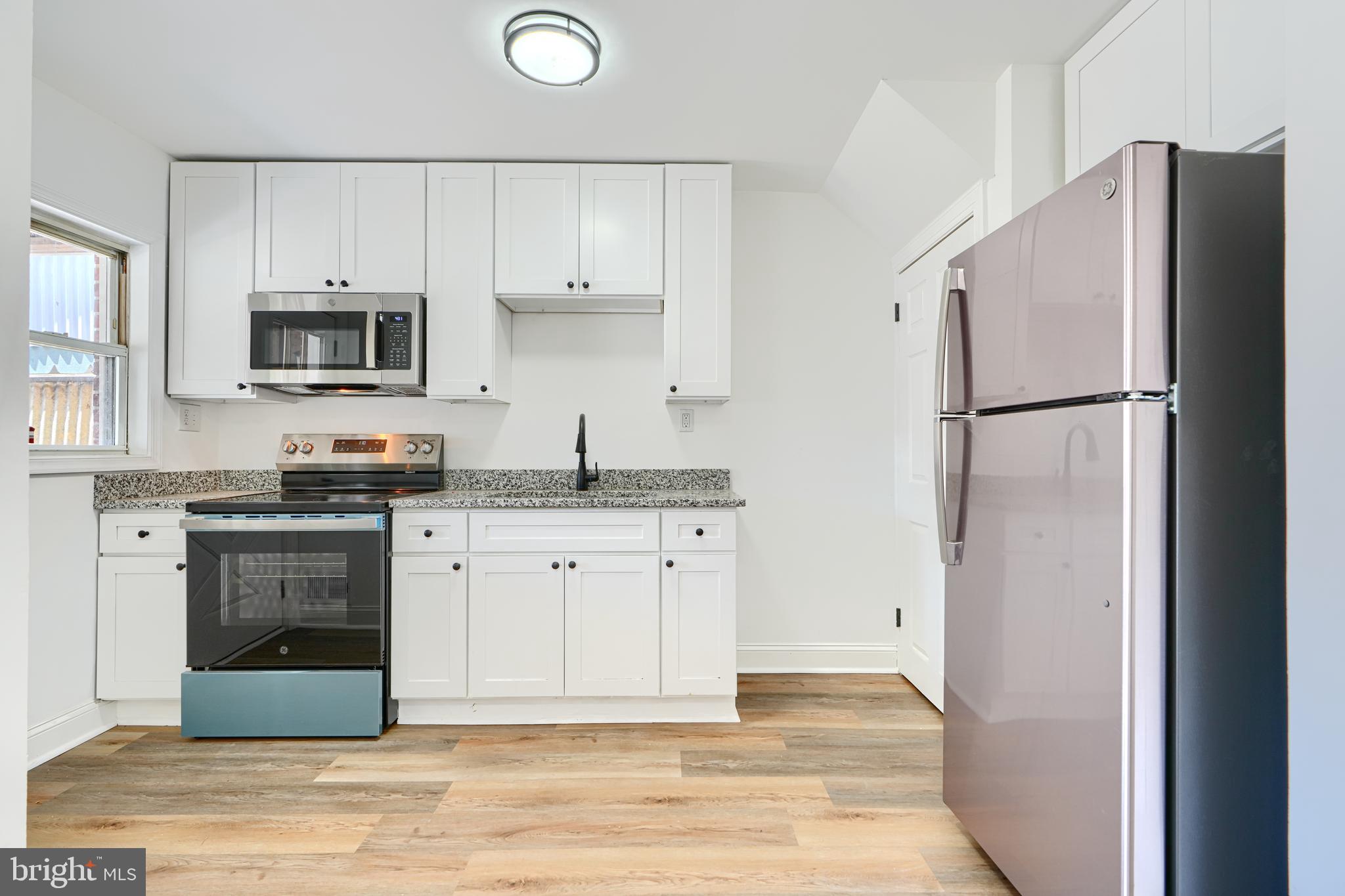 a kitchen with white cabinets and stainless steel appliances
