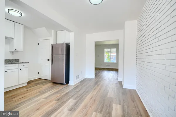 a view of a kitchen with wooden floor and a refrigerator
