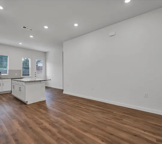 a large kitchen with wooden floor and a sink