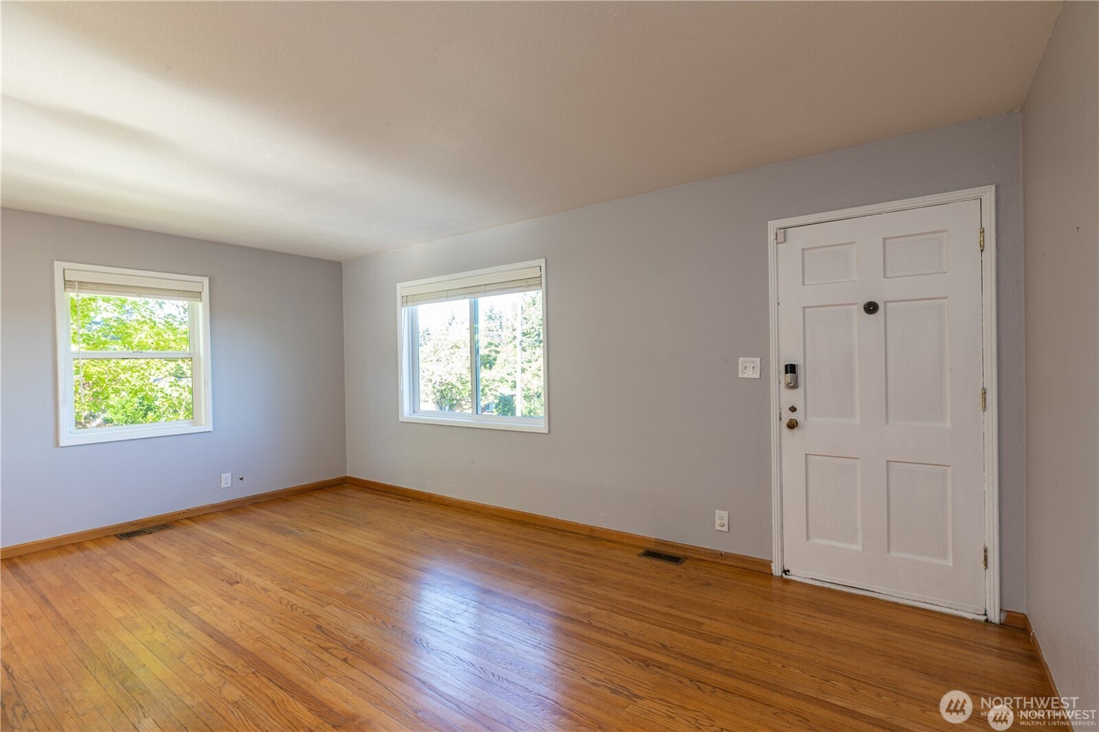 8601 36th Avenue Southwest Seattle, WA 98126 - Photo 5 of 28 a view of an empty room with wooden floor and a window