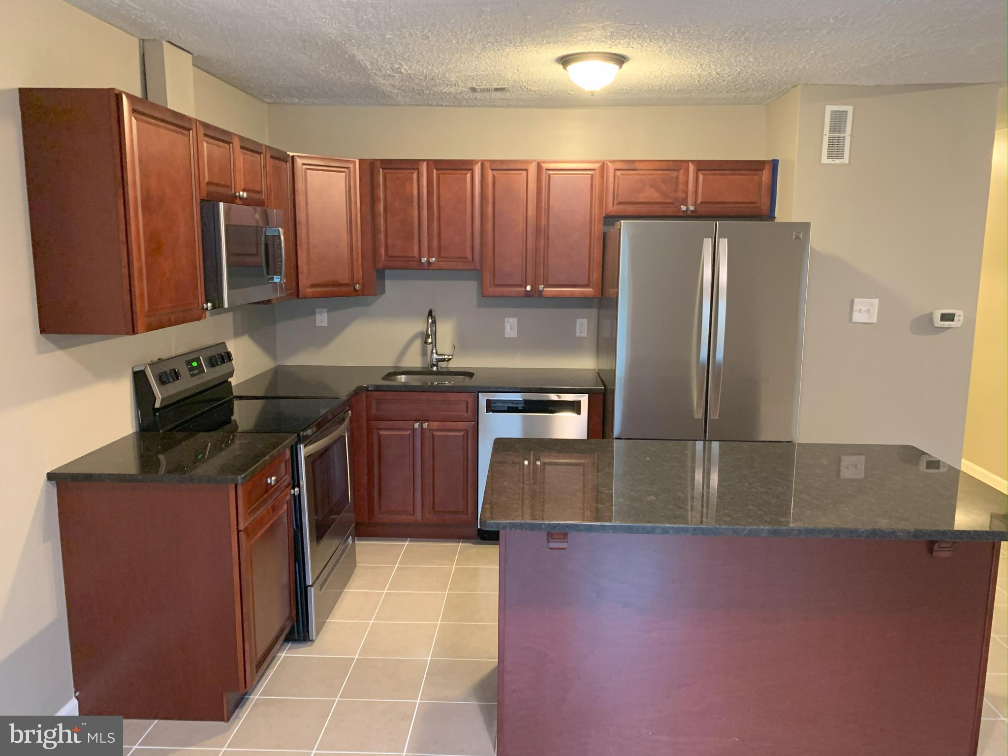 50 Georgetown Road Lindenwold, NJ 08021 - Photo 3 of 17 a kitchen with stainless steel appliances granite countertop a stove a refrigerator a sink a stove with wooden cabinets