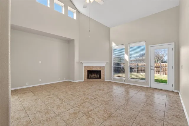 a view of an empty room with a fireplace and a window