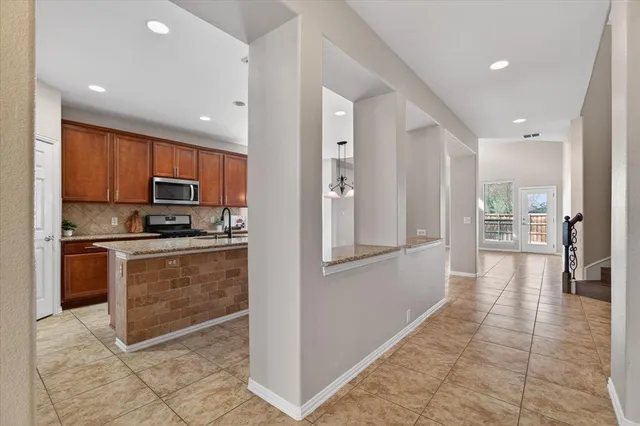 a kitchen with stainless steel appliances granite countertop a refrigerator and a stove top oven
