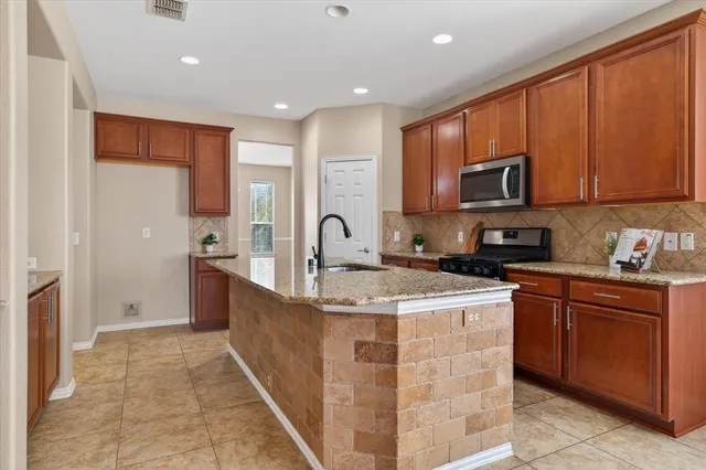 a kitchen with stainless steel appliances granite countertop a sink stove and cabinets