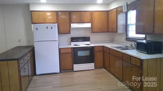 a kitchen with a sink a stove and a refrigerator