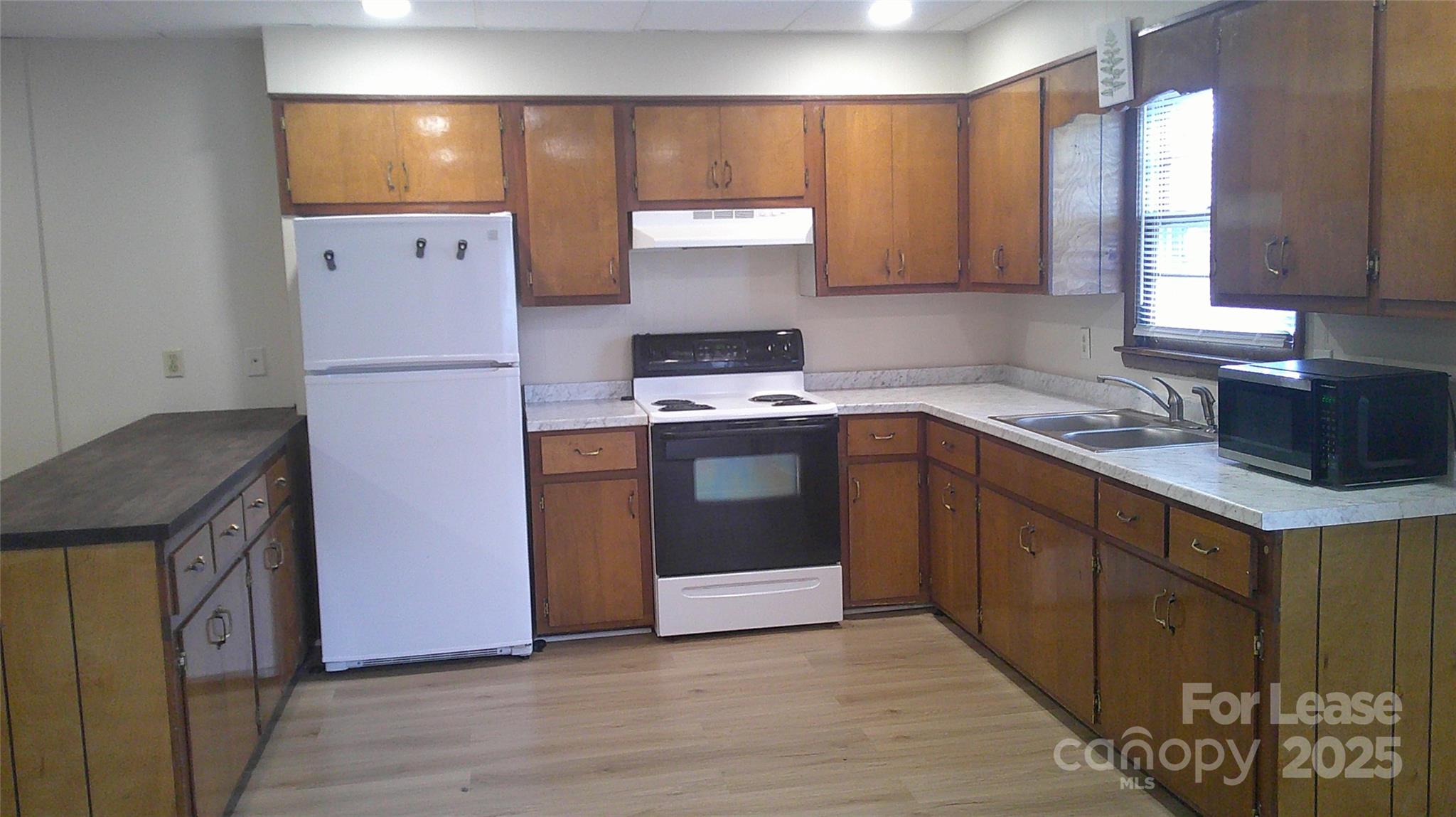 321 Connelly Springs Road, Unit A Lenoir, NC 28645 - Photo 4 of 12 a kitchen with a sink a stove and a refrigerator