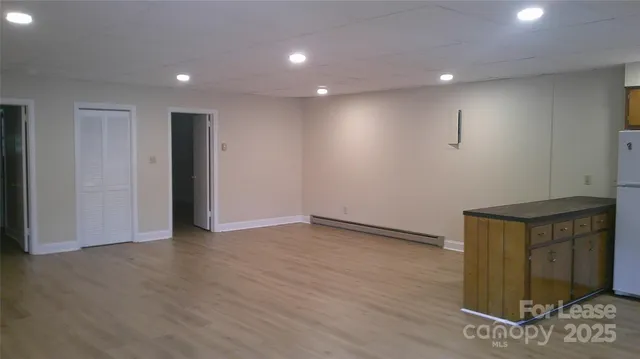 a view of an empty room with wooden floor