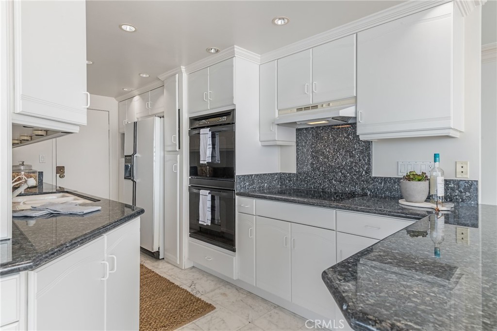 531 Esplanade, Unit 916 Redondo Beach, CA 90277 - Photo 11 of 41 a kitchen with stainless steel appliances granite countertop a sink stove and refrigerator