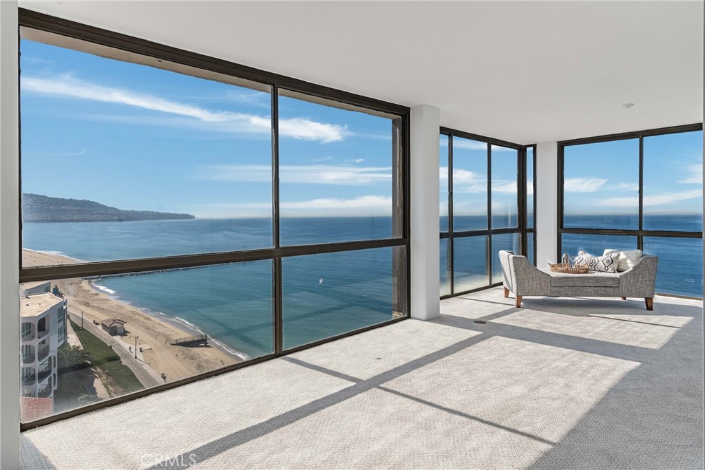 531 Esplanade, Unit 916 Redondo Beach, CA 90277 - Photo 22 of 41 a spacious bedroom with a balcony a bed and glass walk in closet