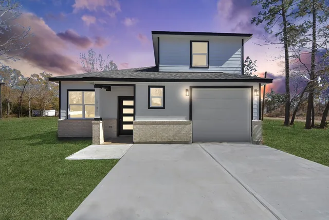 a front view of a house with a yard and a garden