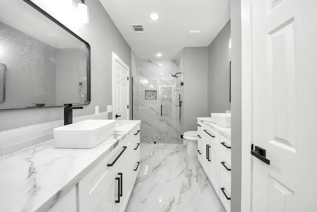a spacious bathroom with a double vanity sink mirror and shower