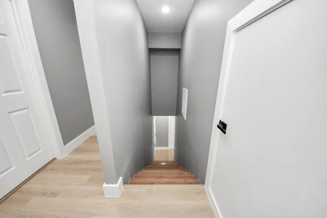 a view of a hallway with wooden floor and staircase